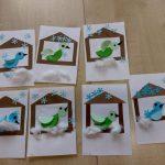 Prace plastyczne dzieci wykonane z kolorowego papieru przedstawiające karmniki dla ptaków a w nich ptaszki.