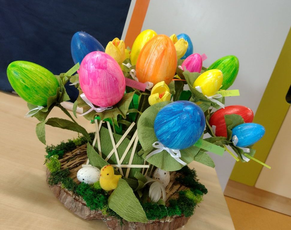 Praca plastyczna w formie stroika. Kolorowe jajka nabite na patyczek wyglądają jak kwiaty. Całość przedstawia się jak bukiet świąteczny.