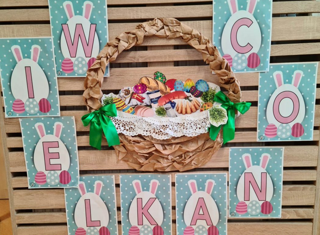 Zdjęcie przedstawia koszyk wielkanocny zrobiony z papieru, dookoła koszyka powieszony jest napis "Wielkanoc"
