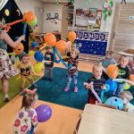 Dzieci tańczą trzymając w dłoniach balony z których zrobione są "kosmoludki"